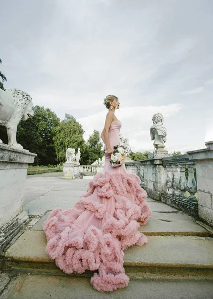 Mode de mariée. Portrait de jeune mariée moderne avec maquillage élégant et coiffure tenant bouquet de pivoine dans ses mains . — Photo