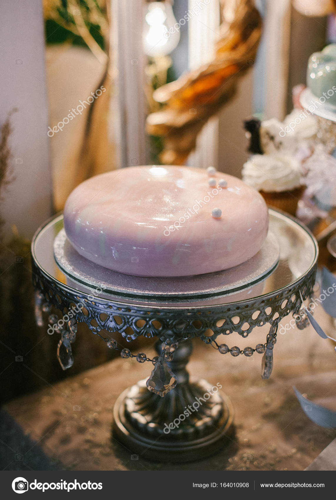 A classic wedding pink cake with glossy surface on silver plate