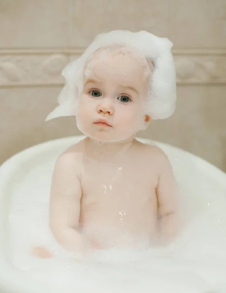 Adorable bebé de 1 año de edad, tomando baño con espuma . Imagen de stock