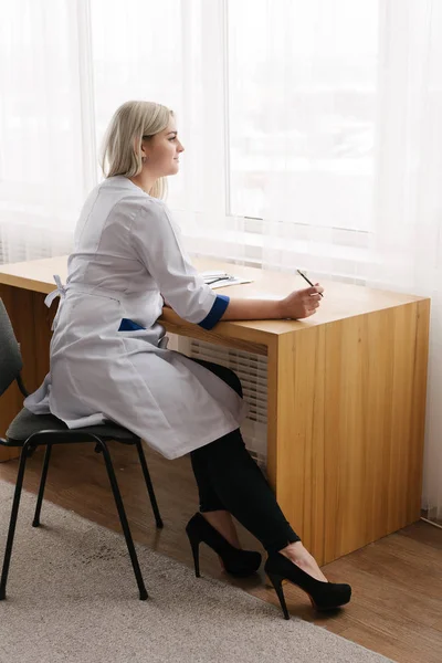 Genç kadın doktor çalışma masası doktorlar Oda yazılı olarak. — Stok fotoğraf