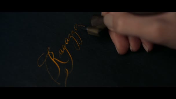 Female hand writes a pen calligraphic signs — Stock Video