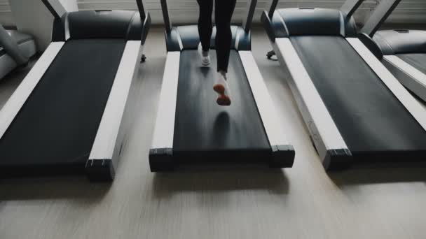 Woman running on a treadmill — Stock Video