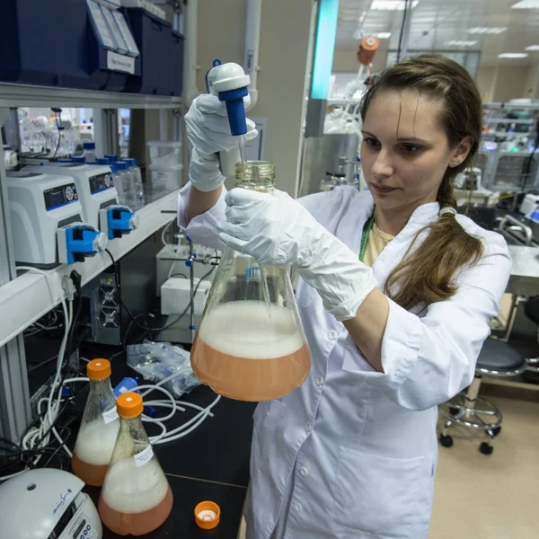 Kadın laboratuvar asistanı Biyokimya elinde şişeye ile — Stok fotoğraf