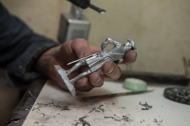 Saint-Petersburg, Rusya-21 Şubat 2017: küçük gruplar kalaylı figürler üreten küçük bir fabrika. Master bir havya ile lekeleri döküm sonra kaldırır.