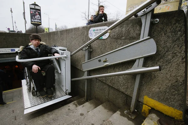 Worker of the underground is  helping to the disabled person — Stock Photo, Image