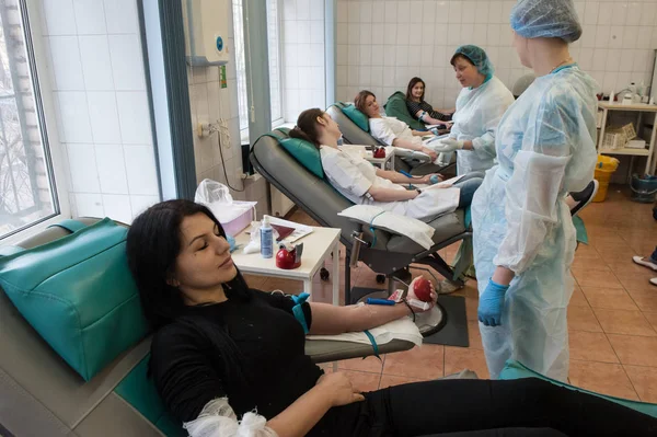 Människor donera blod på en transfusion station — Stockfoto