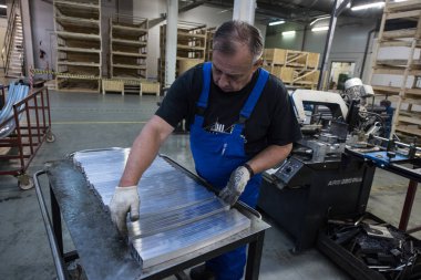 St. Petersburg, Rusya - 29 Haziran 2016: Makine uzmanı, yük arabalarının yapımında kullanılan makinenin alüminyum profilini kesti.