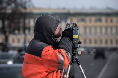 Teodolit ile arazi ölçümleri cente içinde yapar.