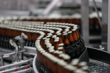 Üzerinde etiket olmadan cam kahverengi şeffaf şişelerde koyu bira.