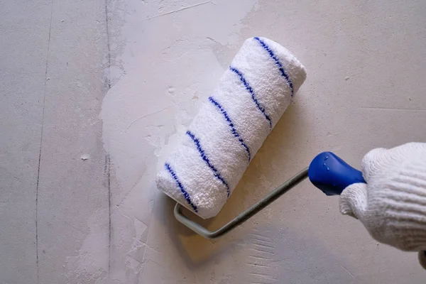 Wall and ceiling painting with a special paint roller in white