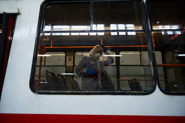 St. Petersburg, Russia - March 19, 2020: A team of orderlies in protective masks, caps and overalls perform sanitary cleaning of the tram's interior, coronavirus preventive measure