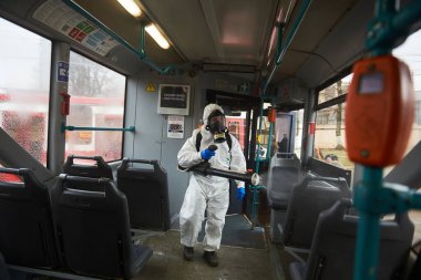 St. Petersburg, Rusya - 19 Mart 2020: COVID-19 salgınına karşı önleyici bir önlem olarak toplu taşımanın dezenfekte edilmesi. Tramvayın içiyle özel korumalı tulumlu çalışanlar ilgileniyor.