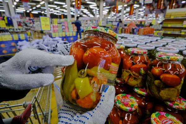 ロシアのサンクトペテルブルク 2020年4月10日 流行中のスーパーマーケット バイヤーは手袋 塩野菜の瓶を身に着けて 彼の手に保持します — ストック写真