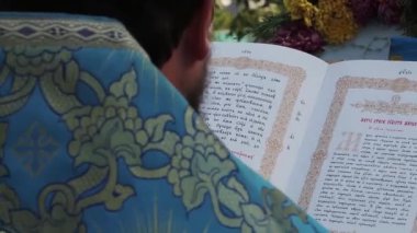 Rahip İncil'i okur.