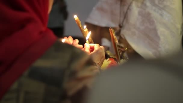 Kněz zapálí svíčky farníci. — Stock video