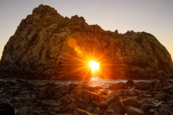 Solnedgången genom nyckel hål Pfeiffer beach, California Royaltyfria Stockbilder