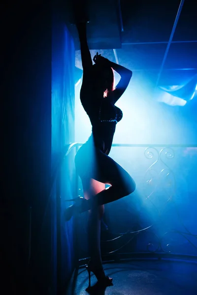 Fille avec beau corps posant dans une boîte de nuit à une silhouette de fête — Photo