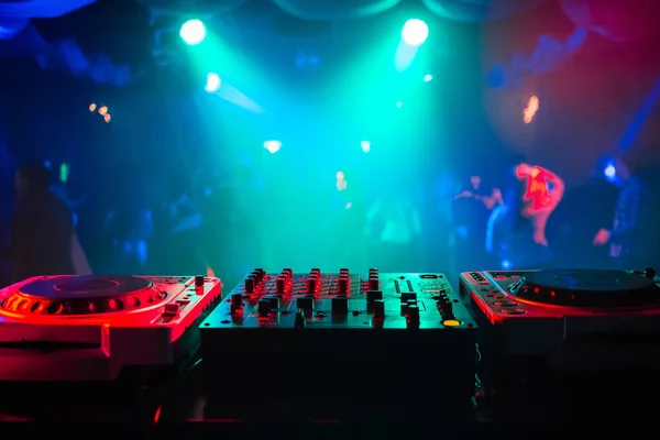 Misturador e uma cabine de DJ na boate em uma festa com um fundo brilhante difuso — Fotografia de Stock