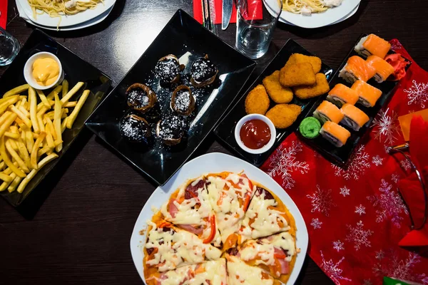 Pizza, Brötchen, Ofenkartoffeln und eine Auswahl an Lebensmitteln auf dem Tisch — Stockfoto