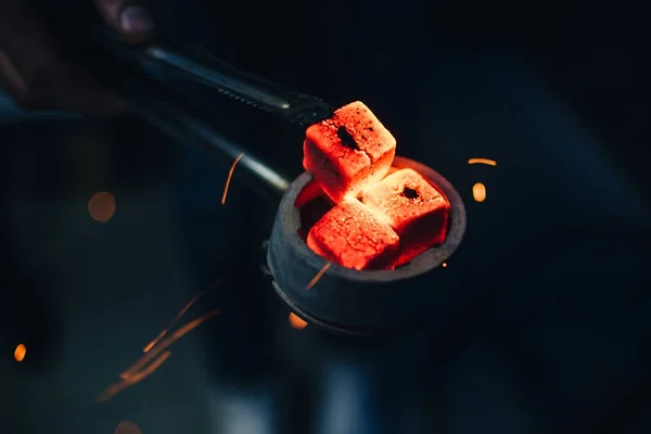 Bol de narguilé avec des charbons chauds rouges dans les mains de narguilé — Photo