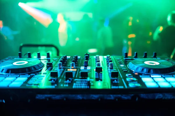 DJ booth at night club party for music mixing with green blurred background — Stock Photo, Image