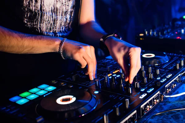 Mixer and DJ booth in nightclub with the hands of DJ mixing music and control regulators — Stock Photo, Image