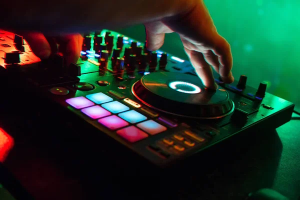 Mezclador y cabina de DJ en discoteca con los brazos de DJ la gestión de la música con iluminación de colores — Foto de Stock