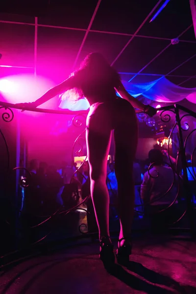 Snella ragazza ballerina con corpo caldo e gambe lunghe e una bella curva sui tacchi lunghi nel night club — Foto Stock