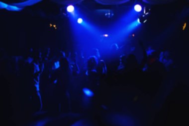 parti ve konser için mavi ışıklar altında gece kulübünde dans pistinde bulanık kalabalığın