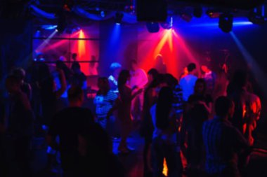 insanlar renkli projektörler altında gece kulübünde dans bulanık siluetleri