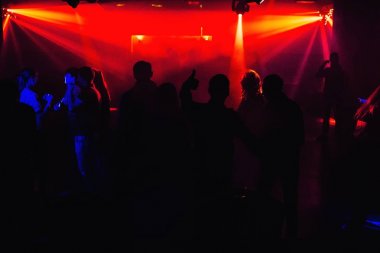 insanlar siluetleri kırmızı sahne ışıkları altında konser gece kulübünde dans pistinde
