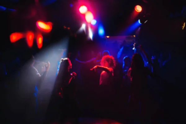 Verschwommene Menschen tanzen auf der Tanzfläche in einem Nachtclub bei einer Konzertparty — Stockfoto