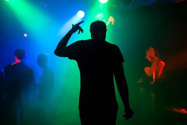 Silhouette of presenter on night club stage at concert back at the event — Stock Photo, Image