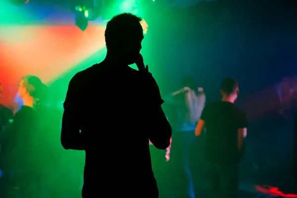 Silueta moderátor s mikrofonem na pódiu nočního klubu na koncertě — Stock fotografie