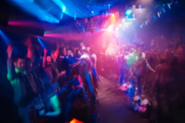 Wazig silhouetten van mensen in nachtclub op evenement met lichteffecten op concert — Stockfoto