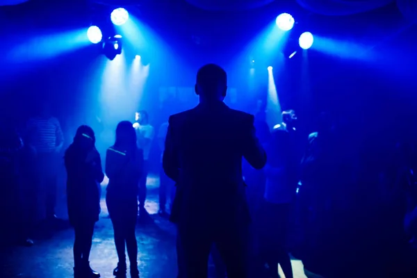 Silhouette führt in die Nachtclubszene mit tanzenden Menschen auf der Tanzfläche bei einer Veranstaltung — Stockfoto