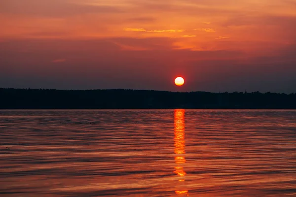 Sol rojo al atardecer con cielo naranja sobre el mar — Foto de Stock