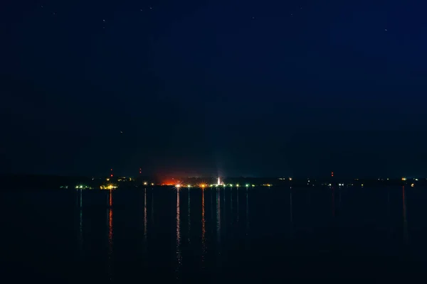 Nacht Stadt Nacht auf Fluss mit Reflexion im Wasser unter Sternenhimmel — Stockfoto