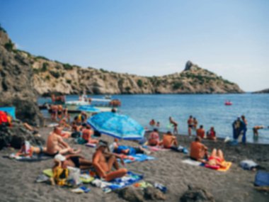 insanlar deniz kumlu plajda dinlenin ve bulanık güneşlenmek