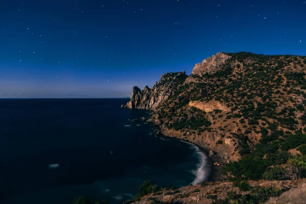 Βουνά και τη θάλασσα τη νύχτα κάτω από το σκούρο μπλε έναστρο ουρανό — Φωτογραφία Αρχείου