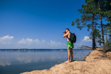 Seyahat fotoğrafçı yaz sahilde arkadan fotoğraflarını sırt çantası ile