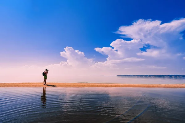 Fotógrafo viajero con mochila tomando fotos del mar en reposo —  Fotos de Stock
