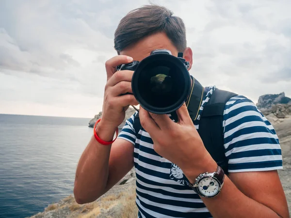 Fotógrafo turista masculino com uma câmera digital e lente grande — Fotografia de Stock