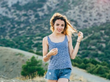 Güzel gülümseme ve uzun saç doğa üzerinde poz ile mutlu genç model kız