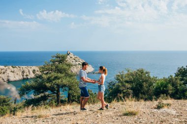 Çift el sarılma ve deniz kenarında birbirine bakarak gençlerin