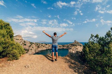 Ücretsiz mutlu erkek traveler gökyüzüne geri kalan kaldırdı silah ile bir dağın tepesinde olduğunu