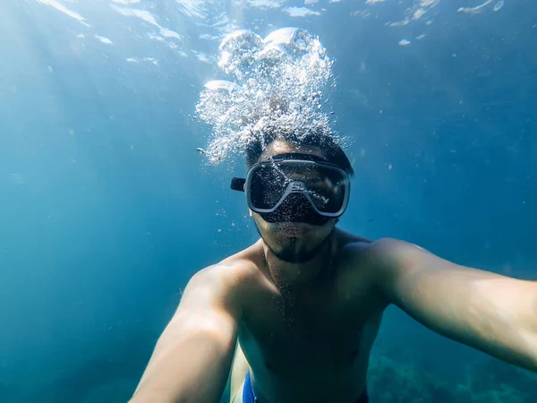 Manliga dykare simmar i havet under vatten med mask och snorkel — Stockfoto