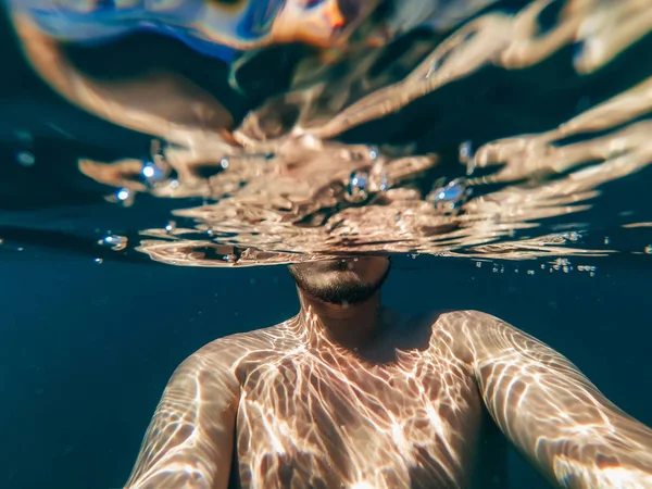 Undervattensfoto av en mans kropp flytande i havet — Stockfoto