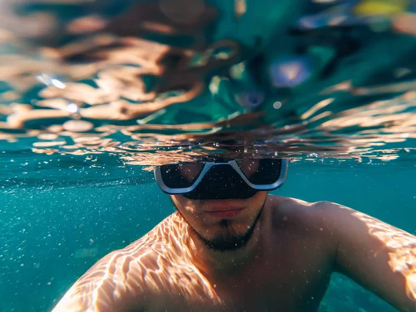 Під водою дайвер чоловік у масці хропіння і приймає селфі — стокове фото