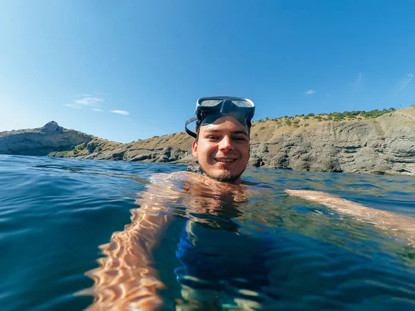 Penyelam laki-laki berenang dalam topeng mengambil selfie di permukaan — Stok Foto